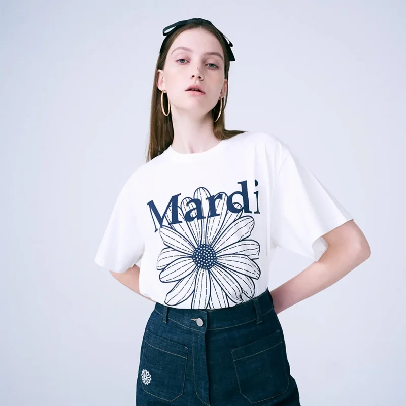 マルディ Tシャツ FLOWER 女性の白いシャツに青いプリント。