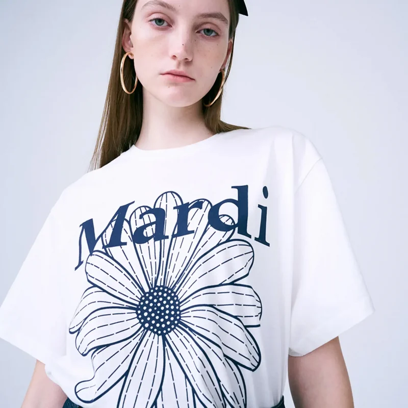 マルディ Tシャツ FLOWER 女性の白いシャツに青いプリント。